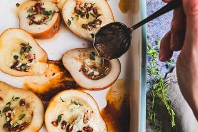 tray of pears and gorgonzola with honey being spooned over