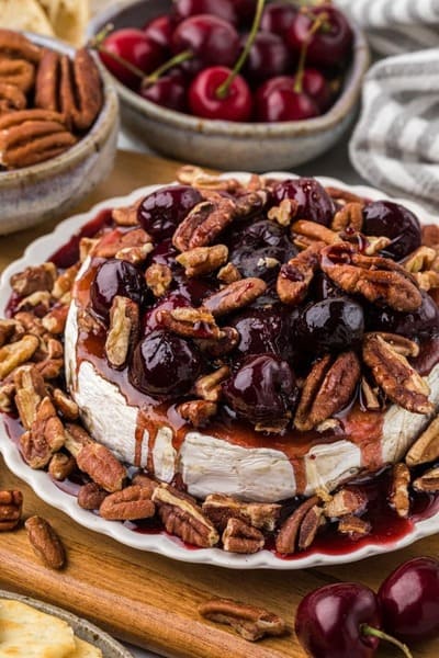 plate of baked brie with pecans and cherry sauce