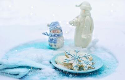 plate of snowflake cookies on a blue blanket in the snow