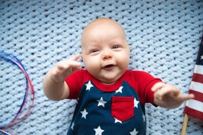 baby wearing red, white, and blue outfit